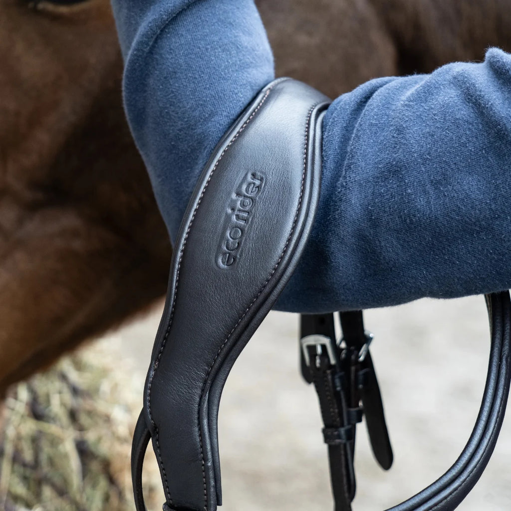 Close-up of an EcoRider anatomical leather headpiece, highlighting the debossed brand logo and thick comfort padding.